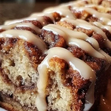 Delicious cinnamon roll banana bread slice with a drizzle of icing