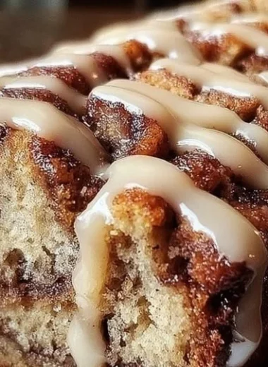 Delicious cinnamon roll banana bread slice with a drizzle of icing