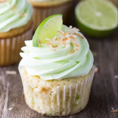Coconut cupcakes with lime buttercream frosting beautifully displayed on a plate.