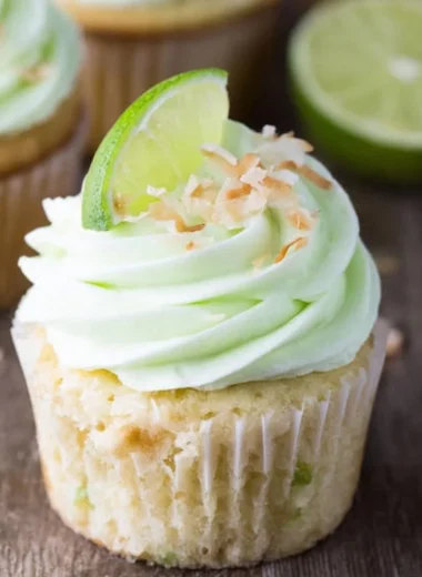 Coconut cupcakes with lime buttercream frosting beautifully displayed on a plate.
