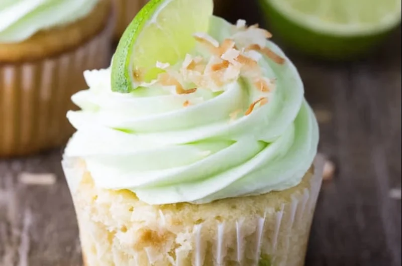 Coconut cupcakes with lime buttercream frosting beautifully displayed on a plate.