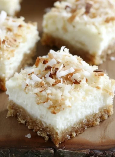 Delicious Skinny Coconut Cheesecake Bars topped with coconut flakes