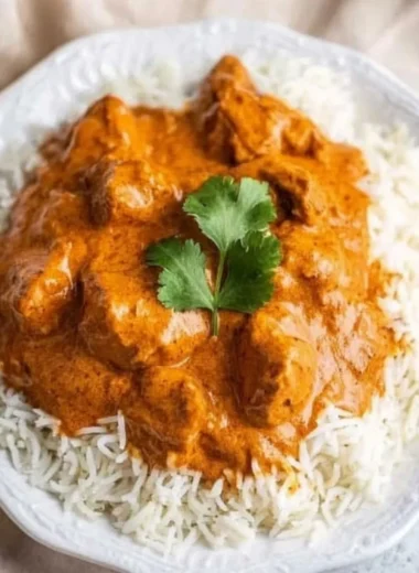 Delicious homemade butter chicken served in a bowl with naan bread.