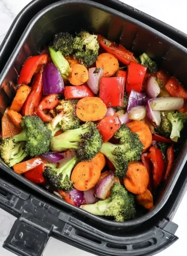 Bowl of colorful air fryer roasted vegetables, ready to serve as a healthy side dish.