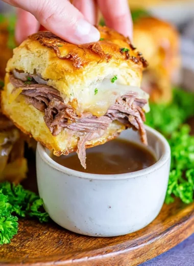 Delicious French Dip Sliders served on a platter with dipping sauce.