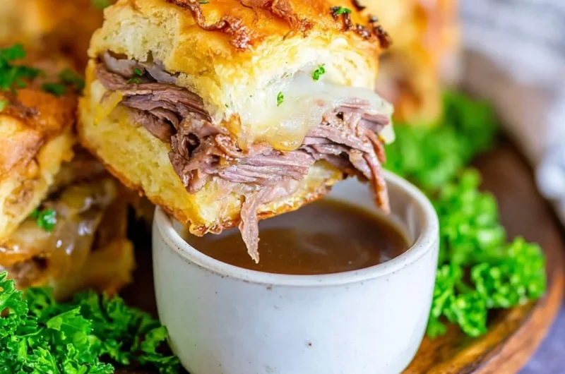 Delicious French Dip Sliders served on a platter with dipping sauce.
