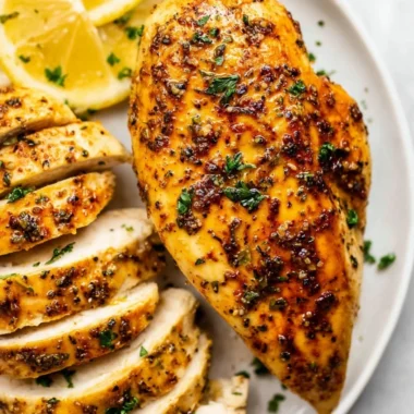 Juicy air fryer chicken breast plated with herbs and spices, ready to enjoy.