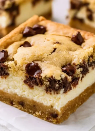Delicious chocolate chip cheesecake bars topped with chocolate chips