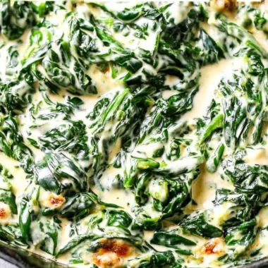 Creamed spinach served in a bowl, garnished with herbs.