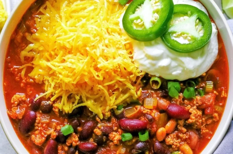 Healthy turkey chili in a bowl garnished with fresh herbs
