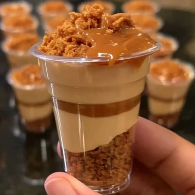 Mini Biscoff cheesecake cups topped with creamy Biscoff spread and crumbs.