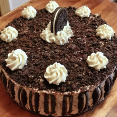 Delicious Oreo ice cream cake topped with Oreo crumbs and whipped cream