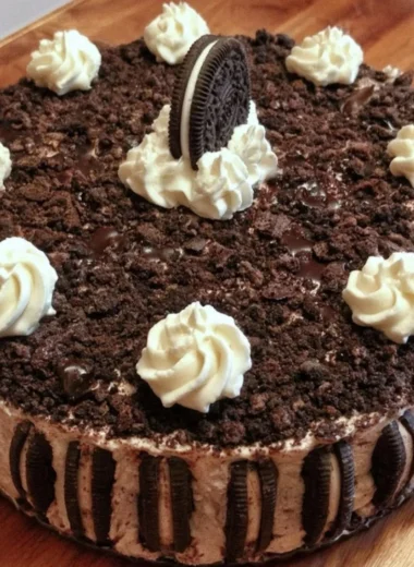 Delicious Oreo ice cream cake topped with Oreo crumbs and whipped cream