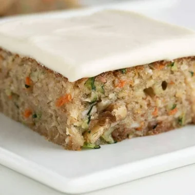 Delicious homemade zucchini bars displayed on a plate with frosting