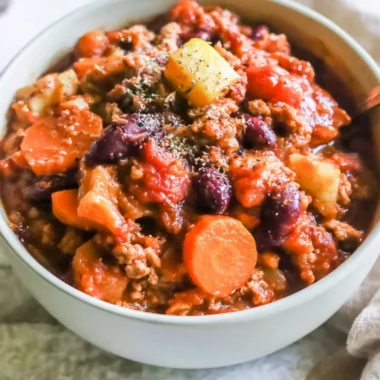 Bowl of Turkey Apple Chili garnished with parsley and chili peppers