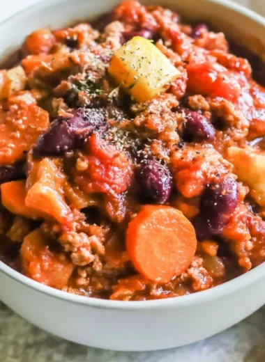 Bowl of Turkey Apple Chili garnished with parsley and chili peppers
