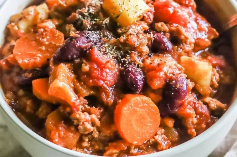 Bowl of Turkey Apple Chili garnished with parsley and chili peppers