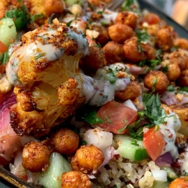 Cozy cauliflower shawarma bowl topped with fresh herbs and tahini sauce