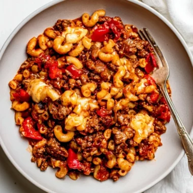 Cozy slow cooker goulash served in a bowl with pasta and vegetables