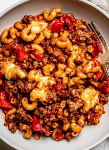 Cozy slow cooker goulash served in a bowl with pasta and vegetables