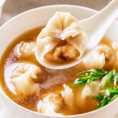 Delicious bowl of cozy wonton soup with rich broth and tender dumplings.