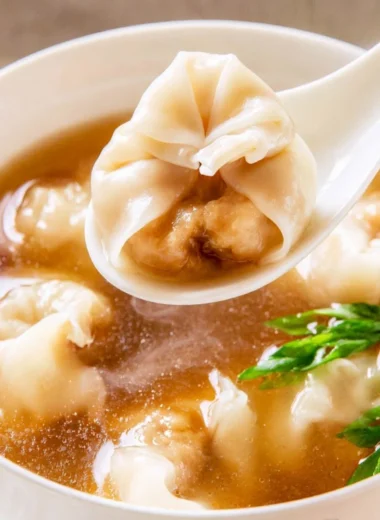 Delicious bowl of cozy wonton soup with rich broth and tender dumplings.