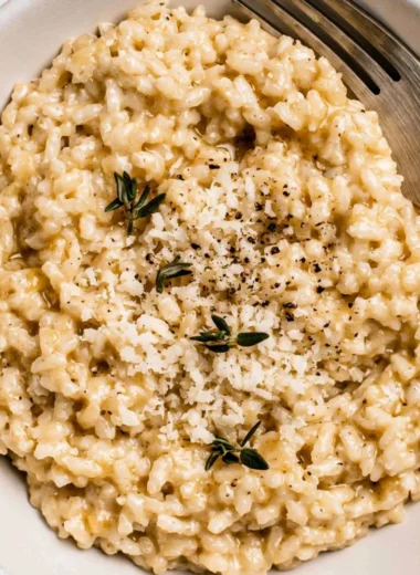 Bowl of creamy risotto topped with fresh herbs and Parmesan cheese