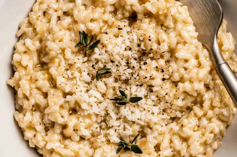 Bowl of creamy risotto topped with fresh herbs and Parmesan cheese