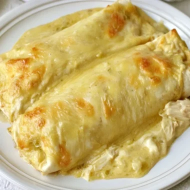 Creamy white chicken enchiladas topped with cheese and sauce