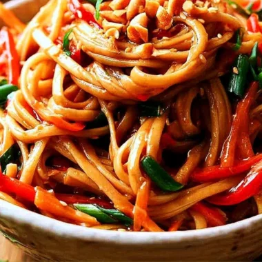 Bowl of easy Thai noodles topped with creamy peanut sauce and vegetables