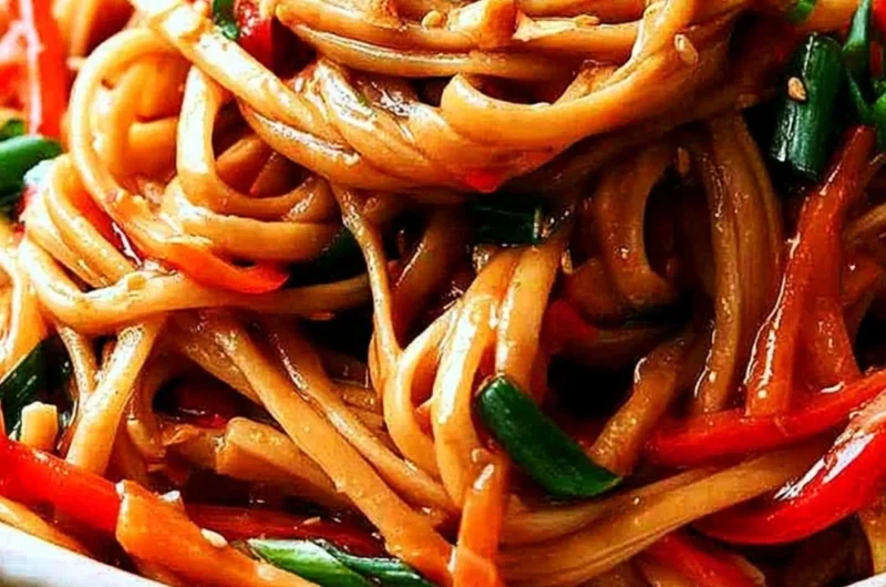 Bowl of easy Thai noodles topped with creamy peanut sauce and vegetables