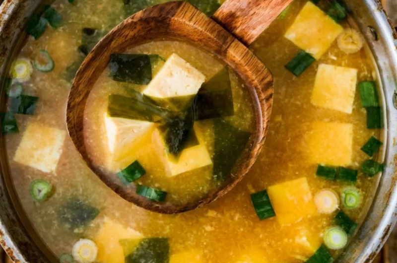 Bowl of homemade miso soup with tofu and green onions garnished