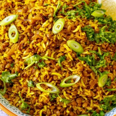 Bowl of Mediterranean lentils and rice with herbs and spices in a cozy kitchen setting.