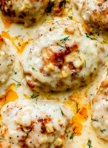 Creamy oven baked chicken thighs served on a plate with vegetables