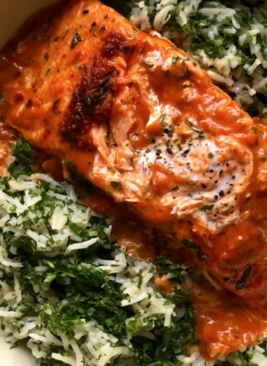 Plate of curried salmon served with herby rice garnished with fresh herbs