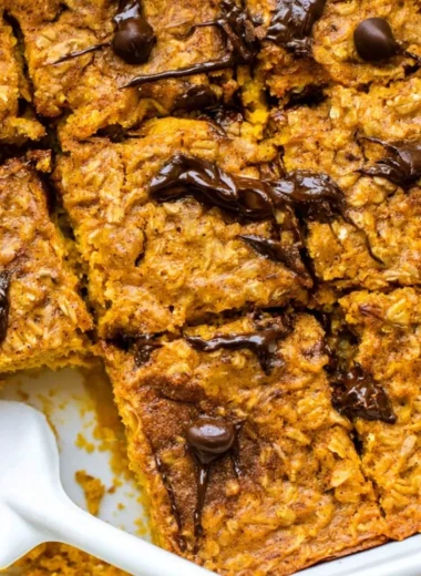 A bowl of pumpkin baked oatmeal topped with chocolate chips and spices