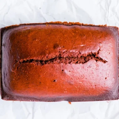 Delicious gingerbread cake loaf topped with icing on a wooden table