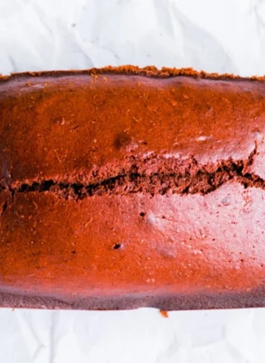 Delicious gingerbread cake loaf topped with icing on a wooden table