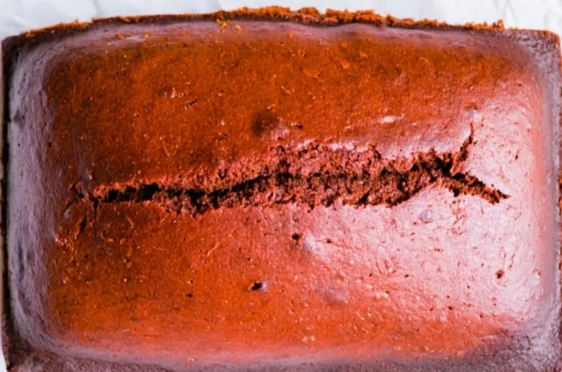 Delicious gingerbread cake loaf topped with icing on a wooden table
