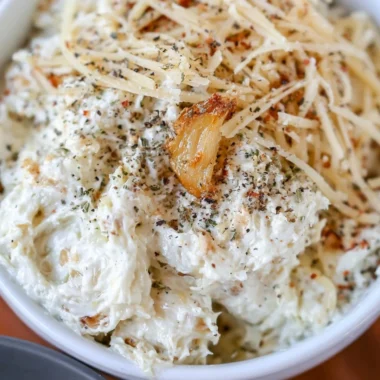 Creamy roasted garlic dip served with fresh vegetables and toasted bread.