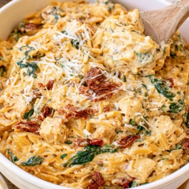 Creamy Tuscan Chicken Orzo in a slow cooker, showcasing vibrant ingredients.