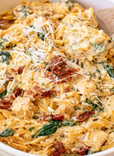 Creamy Tuscan Chicken Orzo in a slow cooker, showcasing vibrant ingredients.